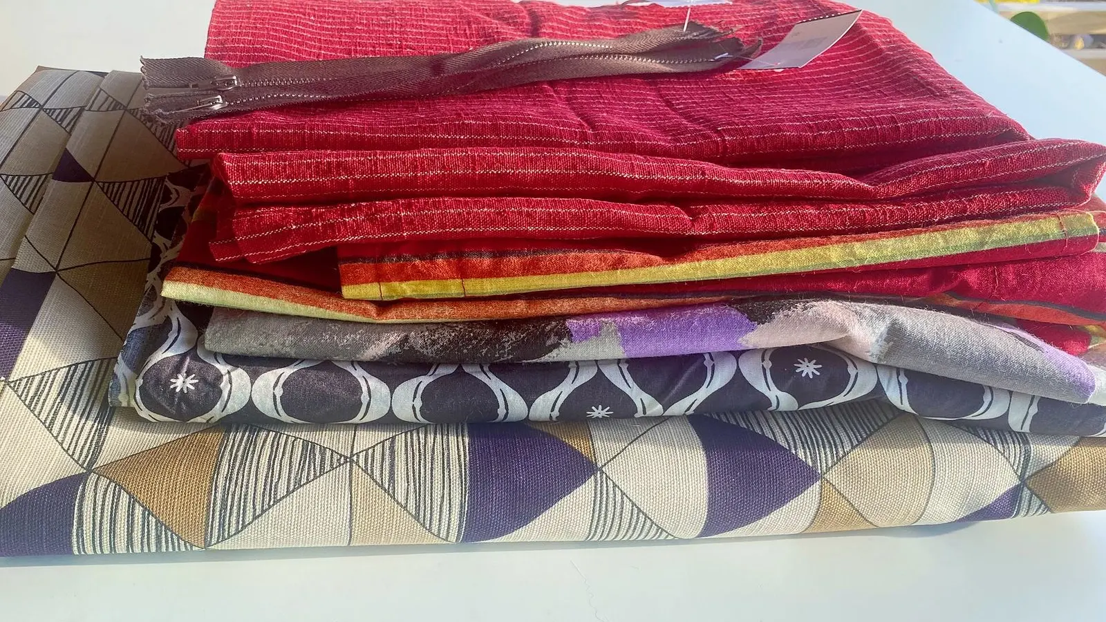 Offcuts of printed and plain fabric laid loosely on top of one another