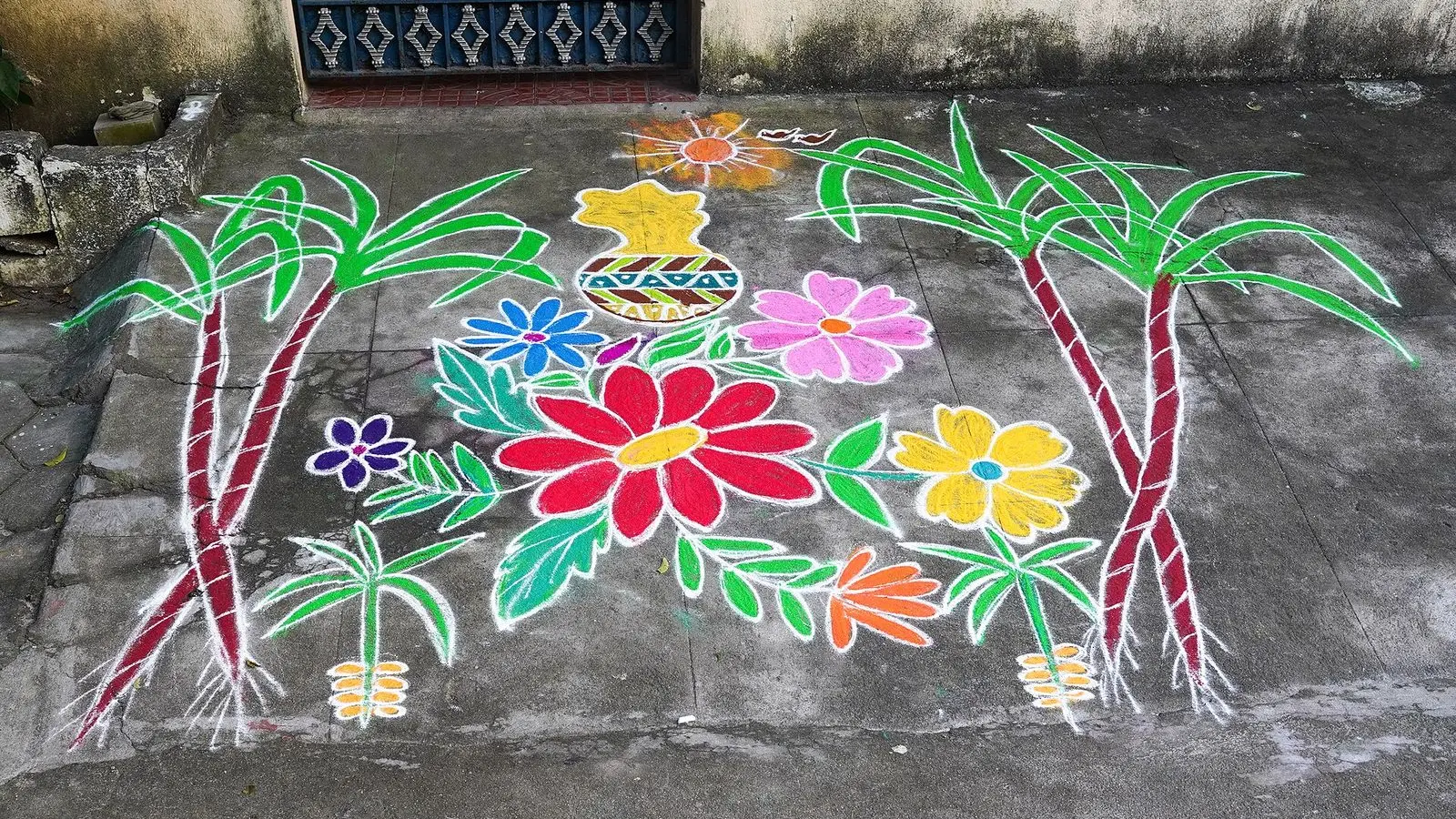 A coloured kolam of flowers and sugarcane drawn on a street in Uthandi, Chennai, for Pongal