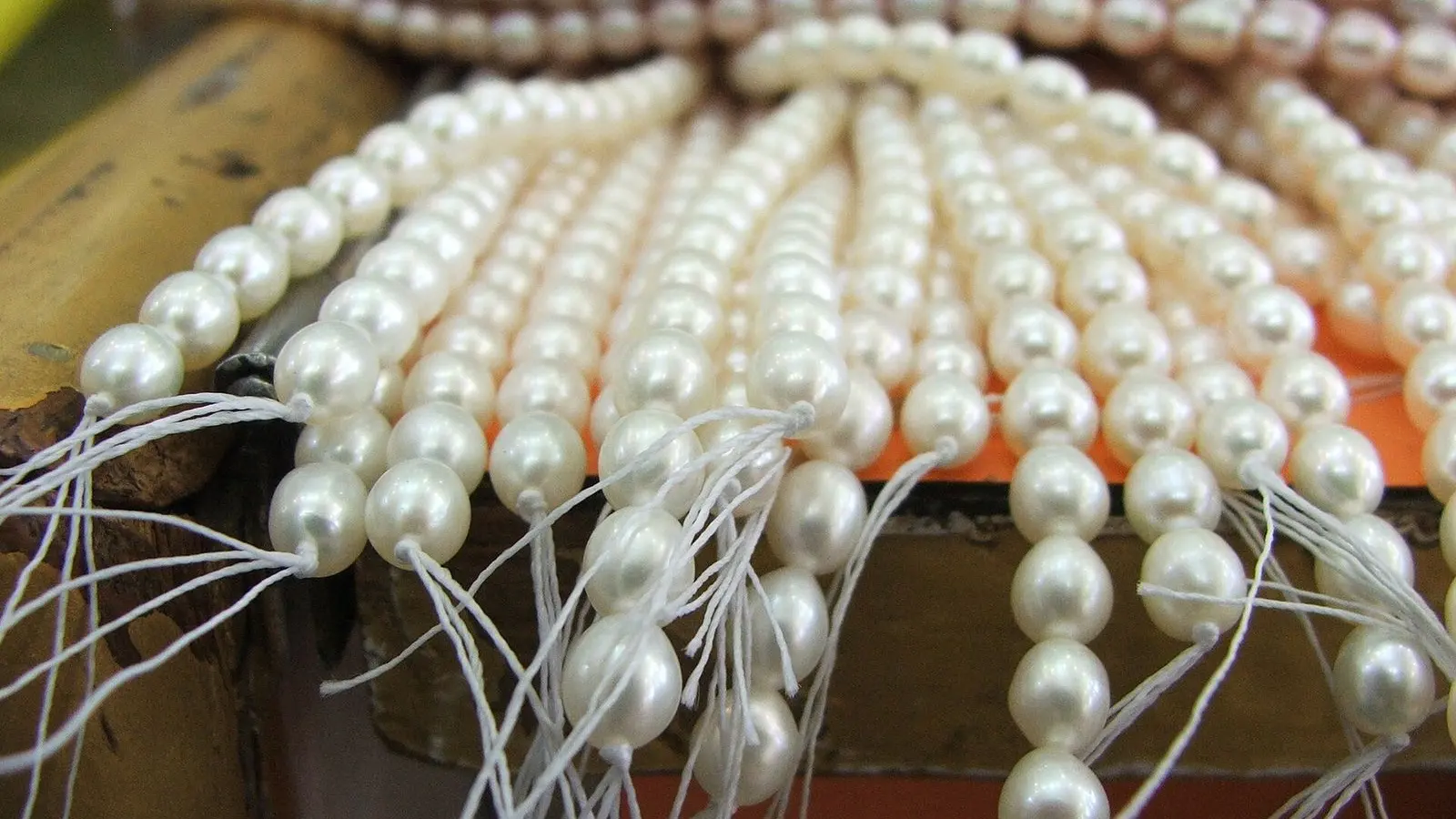Strands of cream pearls tied in bunches on a shop counter in Laad Bazaar, Hyderabad