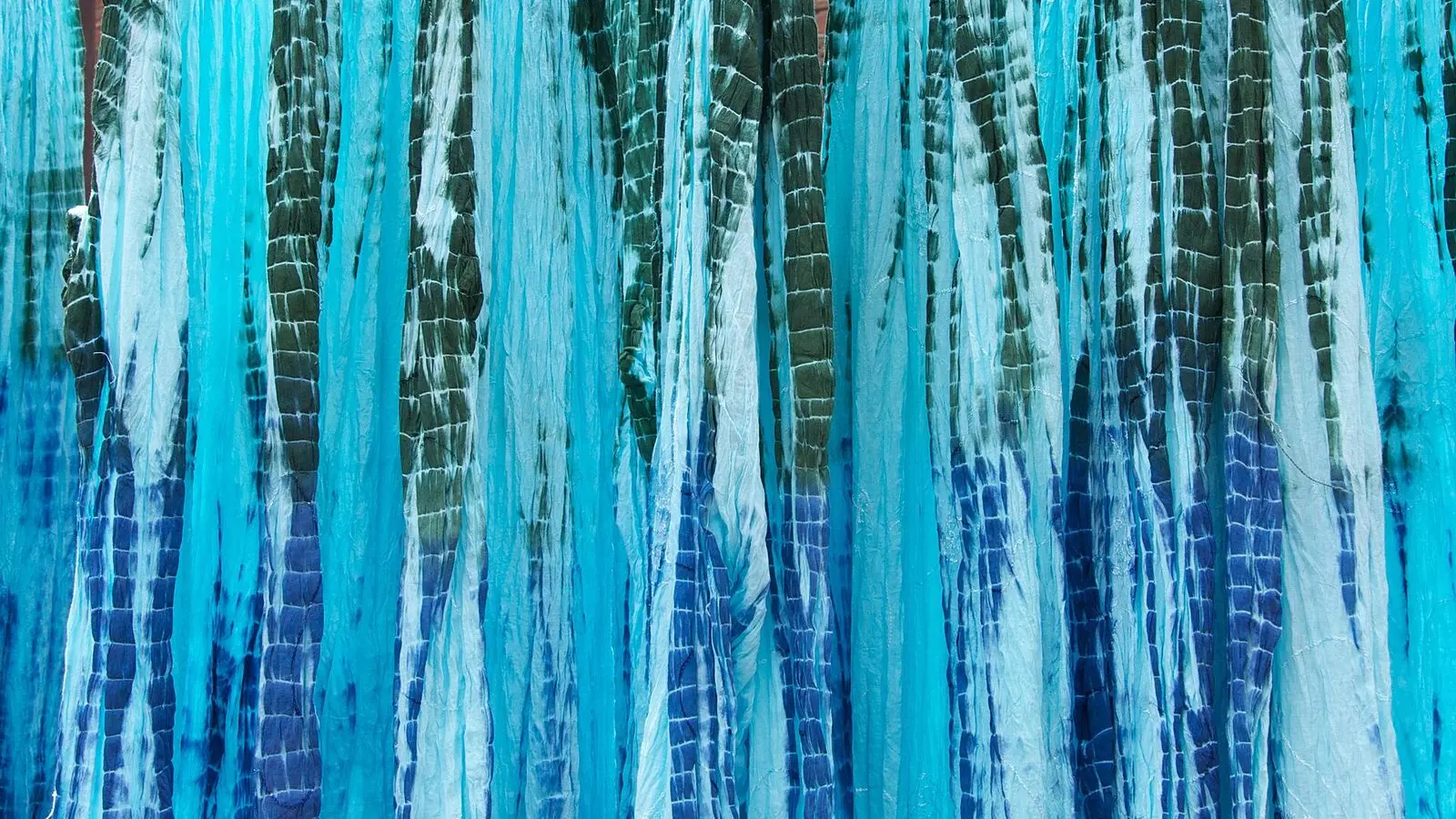 Turquoise and indigo tie-dyed dresses hung up to dry in Jaipur