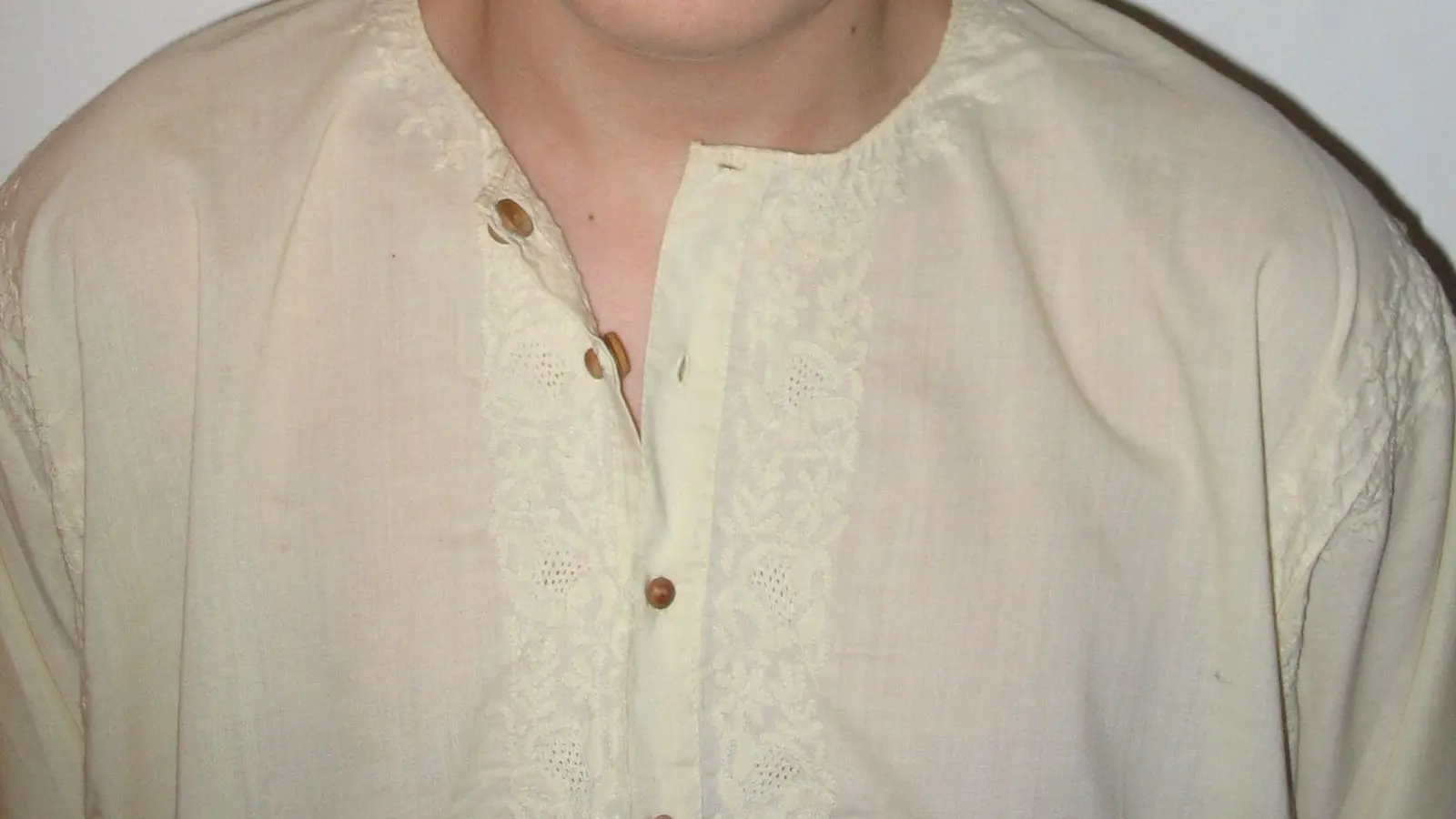 The front of a cream cotton kurta with chikan embroidery along the placket and wooden buttons