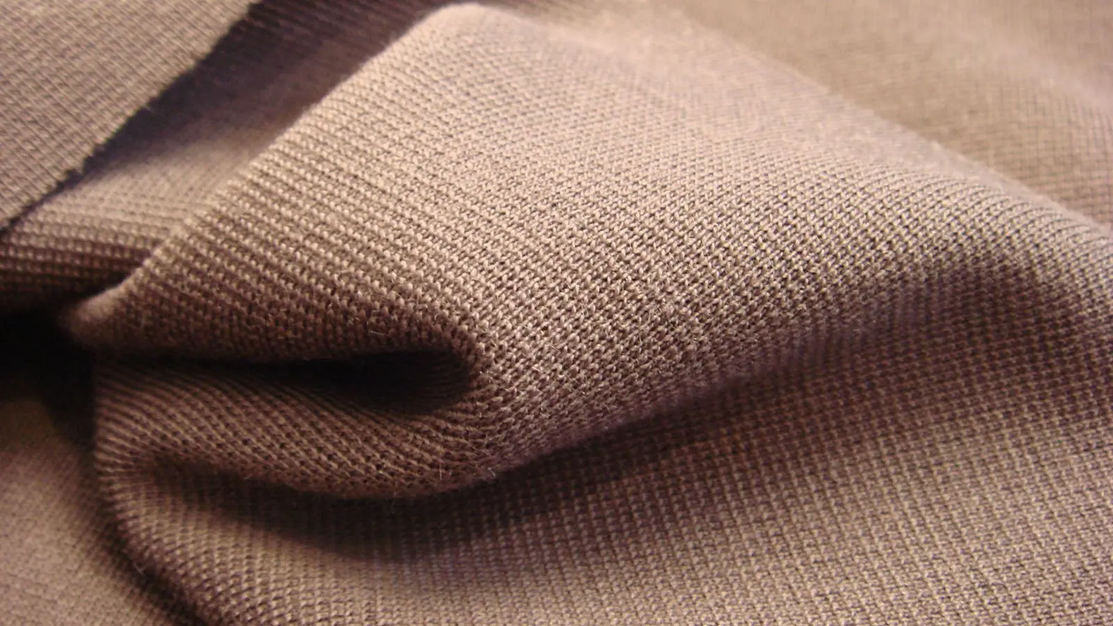 Close view of brown single jersey knit fabric gathered in soft folds