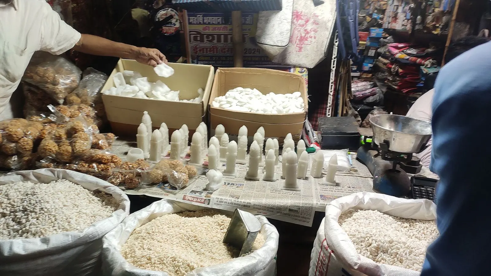 Sacks of puffed rice, white sugar figures and sweets laid out on a Diwali market stall in Paharganj, Delhi