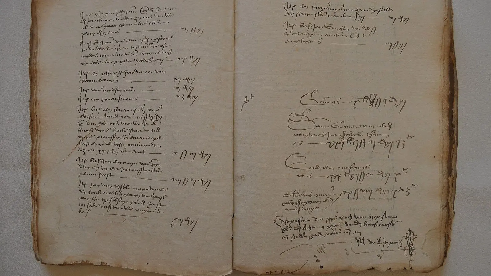 An old account book lying open, its pages filled with handwritten entries in brown ink