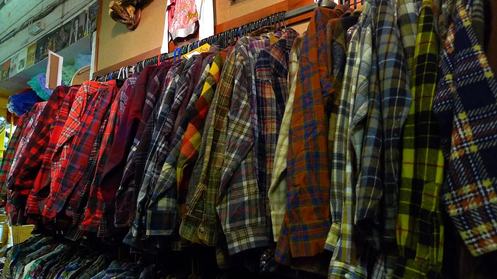 Plaid cotton shirts hanging close together on a clothes rack