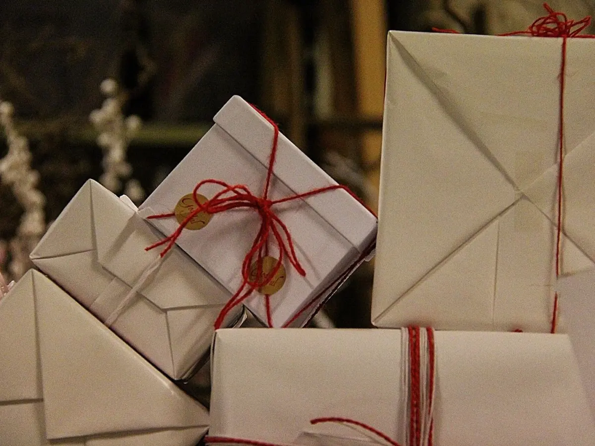 Parcels wrapped in brown paper and tied with red string, piled together